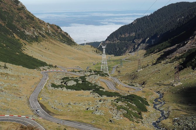 Brasov Private Tour: Transfagarasan road & Poienari Fortress - Vidraru Dam adds scale after the mountain road